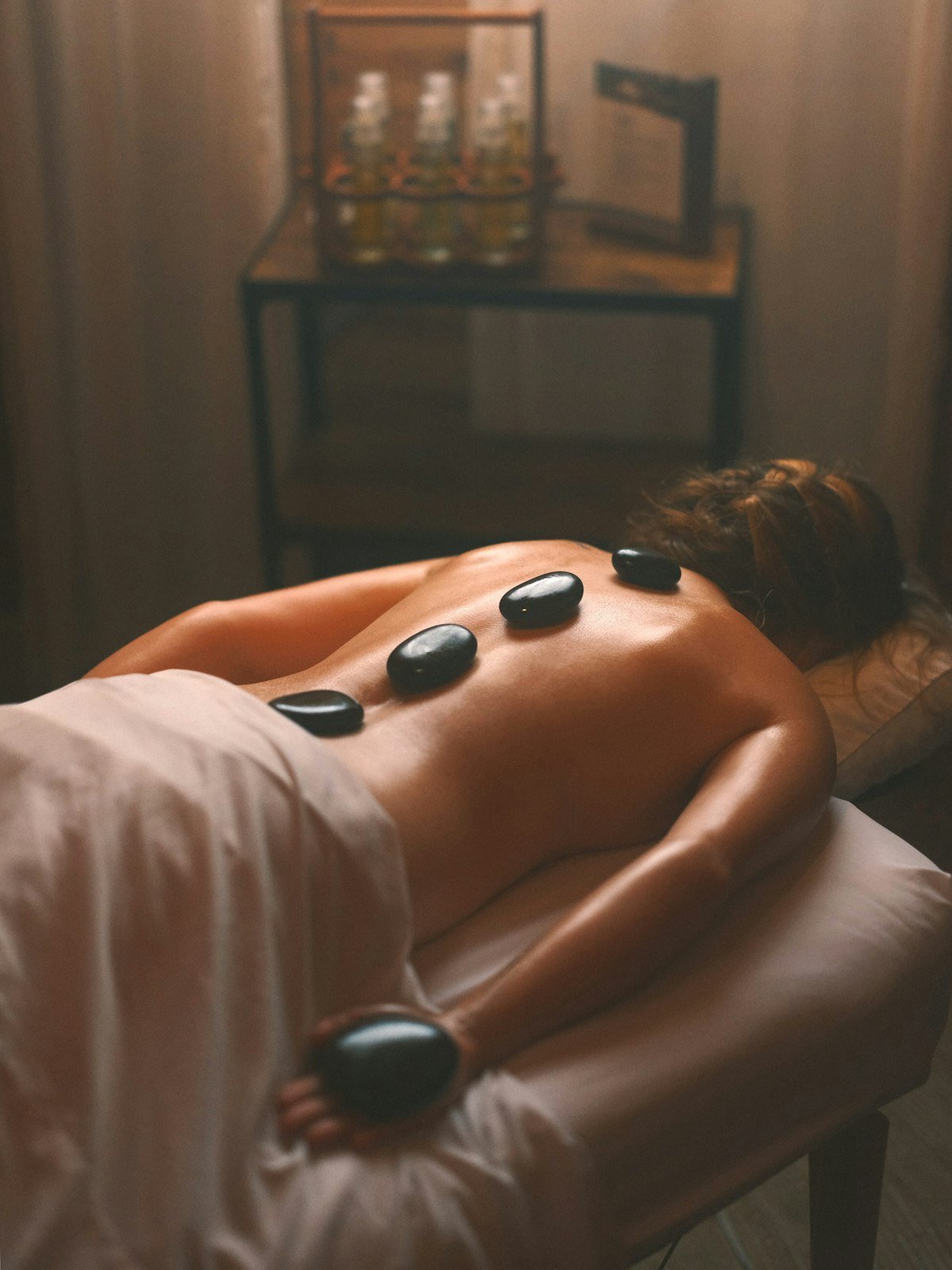 Pierres de massage chaudes posées sur le dos d'une personne allongée